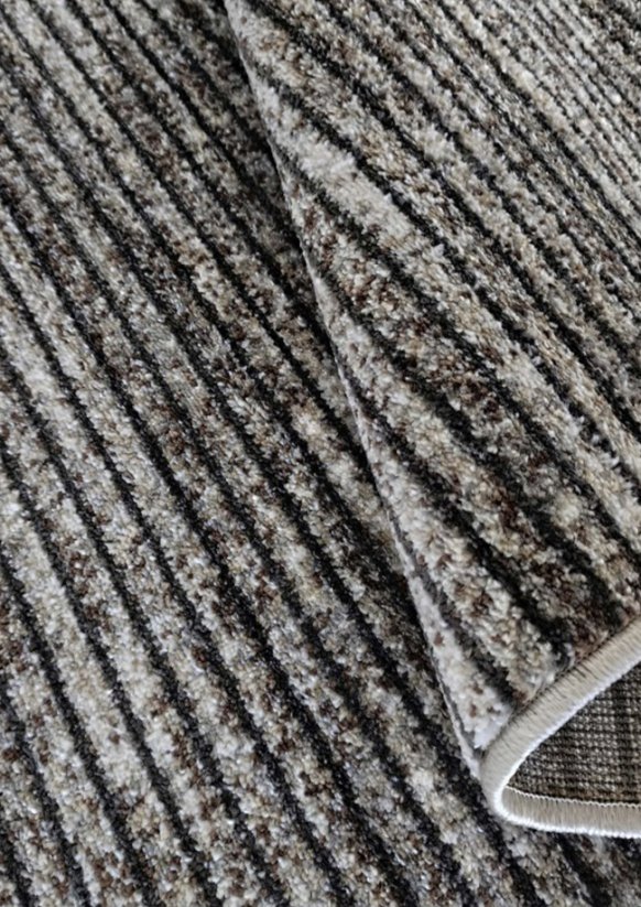 Pruhovaný koberec šedé barvy vhodný do předsíně.